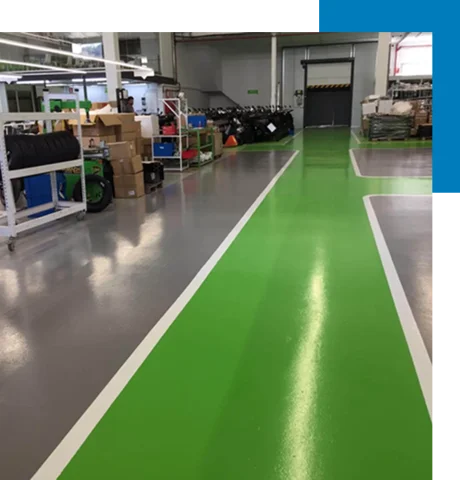 bright green epoxy pathway bordered by white lines, and a surrounding gray epoxy floor