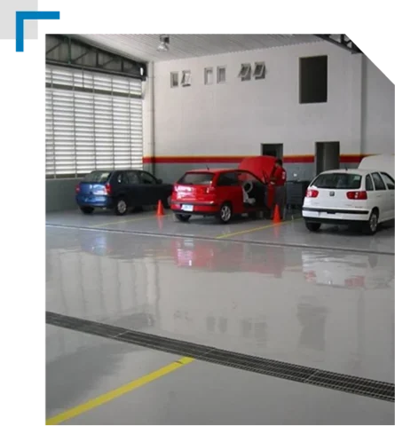 garage interior showing three cars and a bright, glossy gray epoxy floor