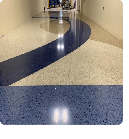 hallway with white, tan, and dark blue speckled epoxy flooring