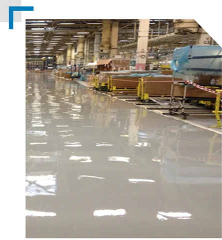 highly glossy epoxy floor in a long, busy industrial or factory setting