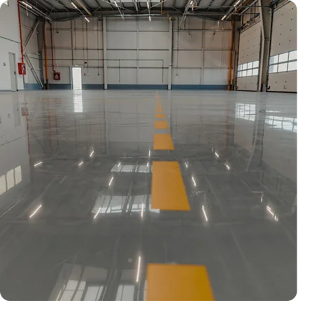 reflective gray epoxy floor in a large industrial or warehouse space