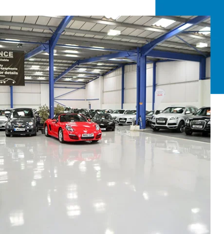 showroom with many cars parked on a highly reflective, glossy light gray epoxy floor